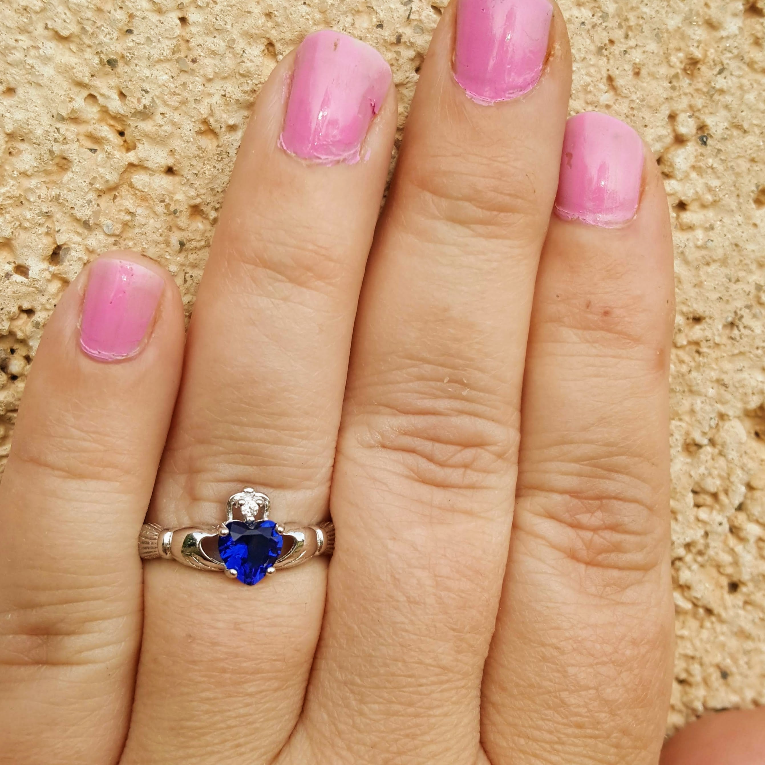 Blue heart ring on hand